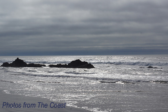 Lava rocks, sparkling winter ocean and dramatic sky